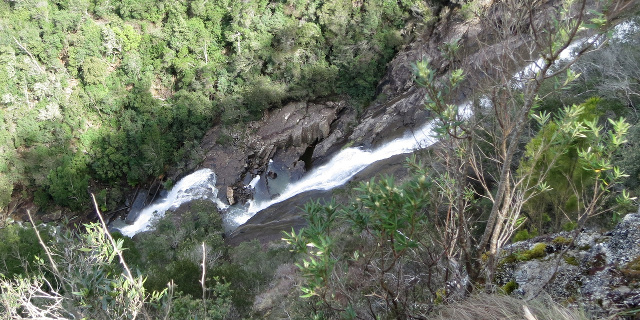 Photograph of water flowing down sloping rock in a gorge.