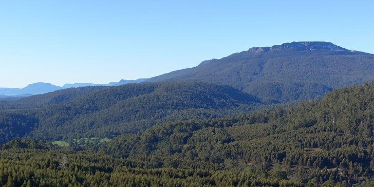Photograph of line of mountain bluffs under a clear blue sky.
